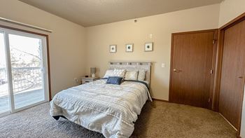 a bedroom with a bed and a sliding glass door